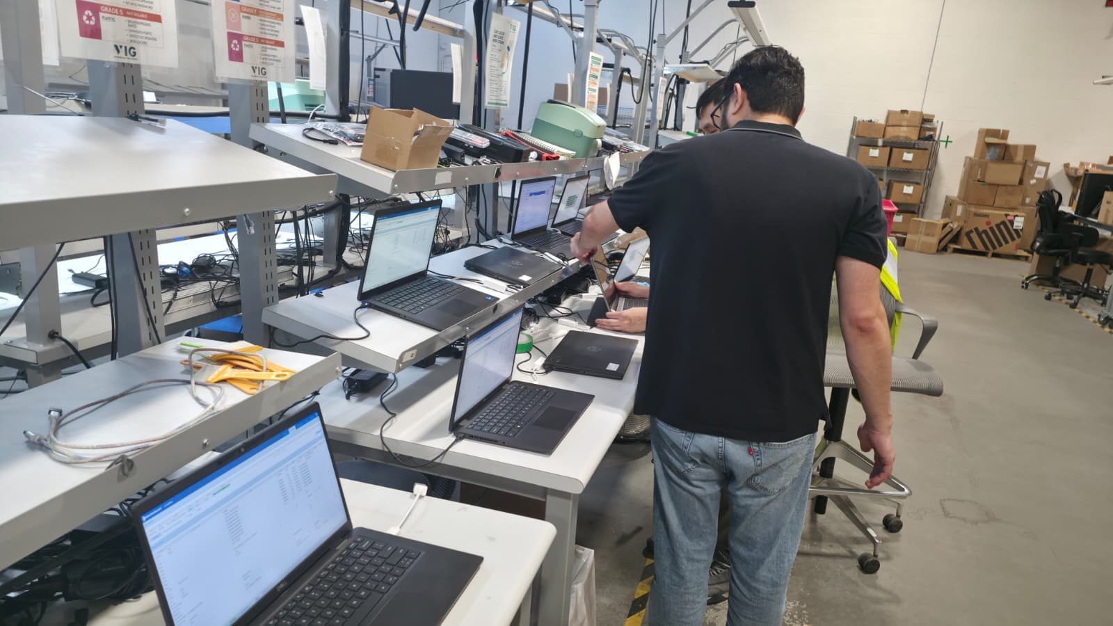 A VIG technician auditing laptops at the grading bench in the Dallas facility